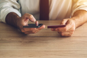 Man using a smartphone to make a credit card payment.