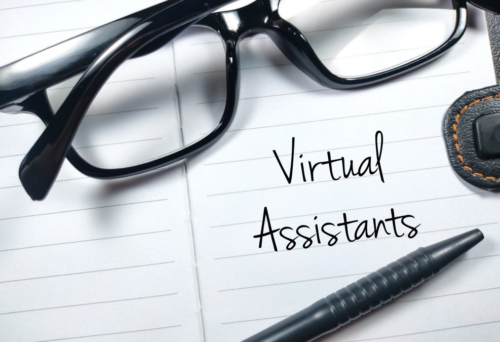 Virtual Assistants written on a piece of paper in black ink with pen and glasses sitting on top of the paper
