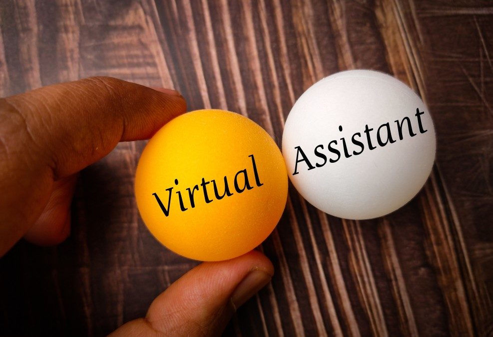 a person holding two golf size balls. One is golden and says Virtual. The other is white and says Assistant